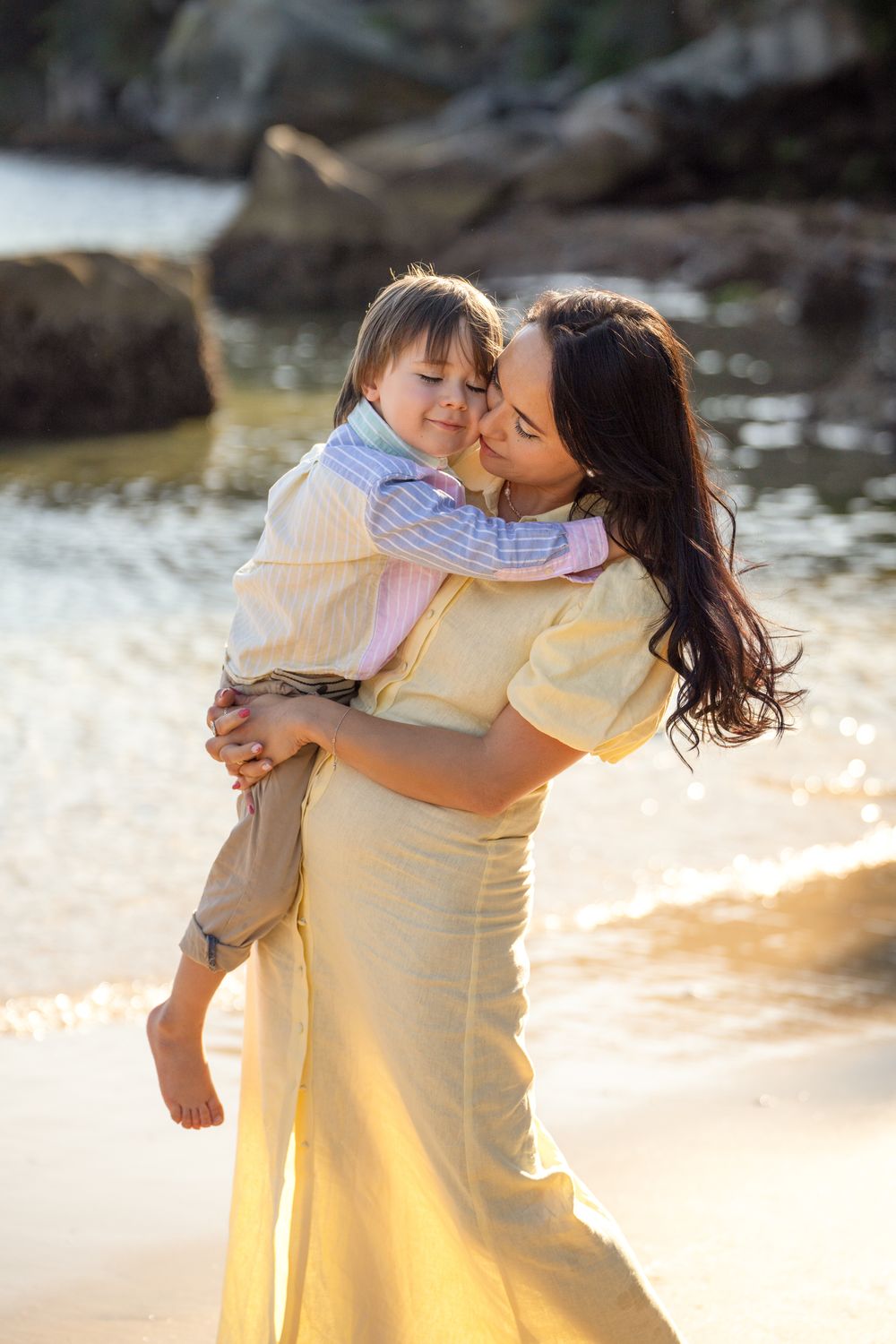 Mother giving a sweet kiss to her son at Collins Flat Beach during a Northern Beaches family photoshoot