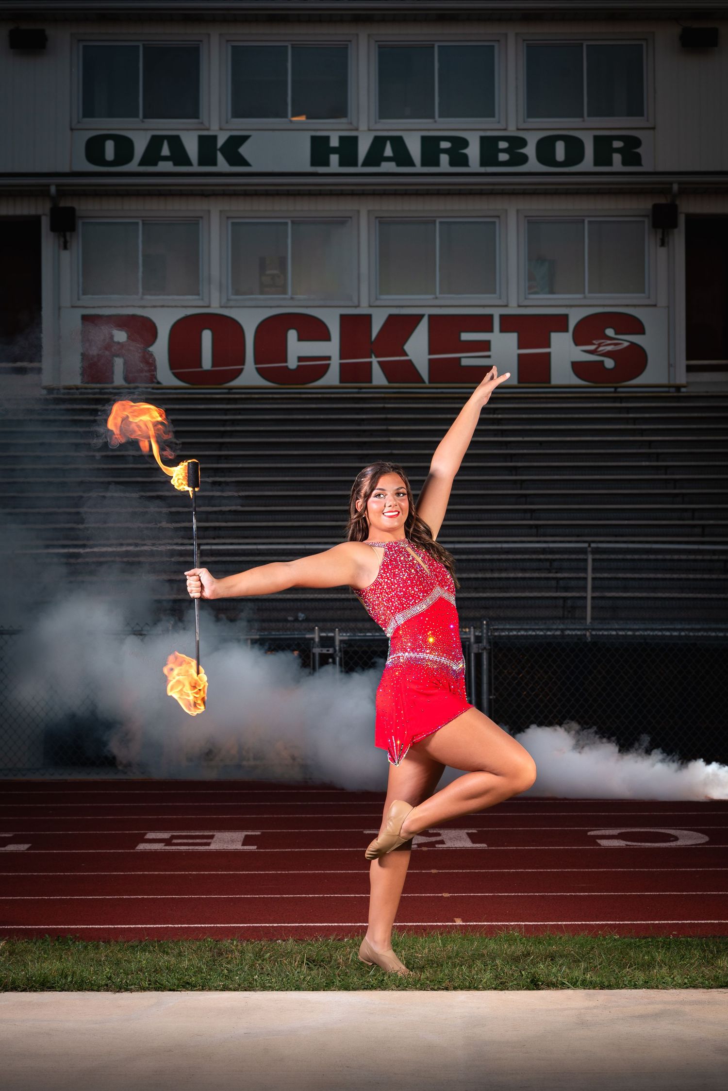 High school baton twirler performing on track field at Oak Harbor stadium – Ohio senior athlete portrait