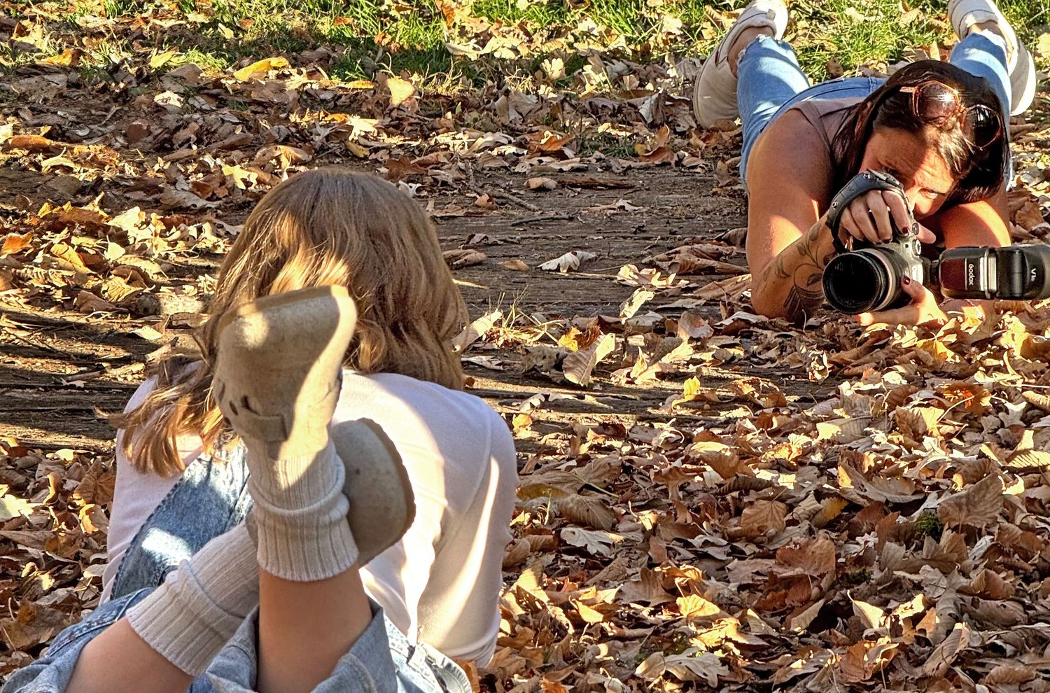 A photographer photographing in the leaves at a Senior Session
