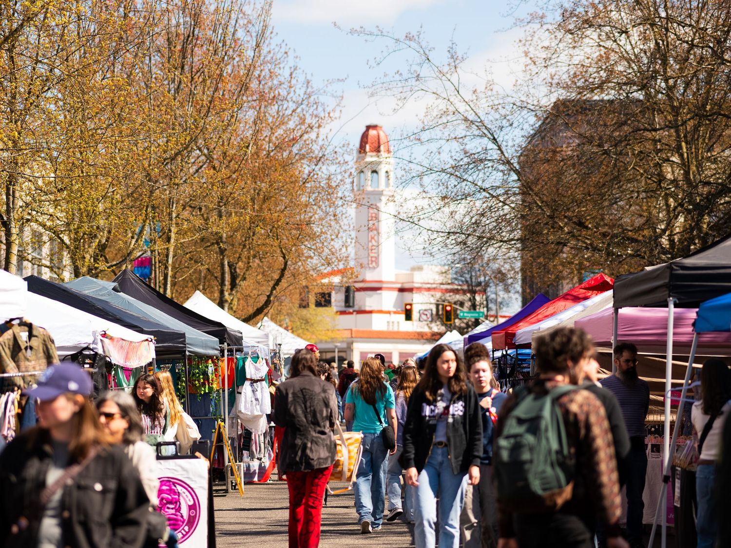 A busy farmers market at Memorial Union Terrace near the UW-Madison campus with vendors and shoppers on a fall day.