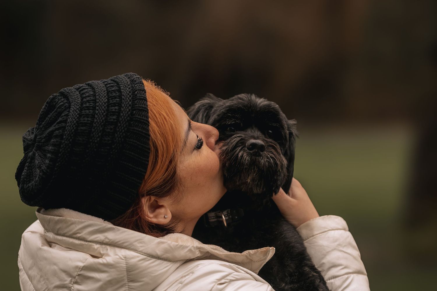Black dog being kissed by owner at end of life session