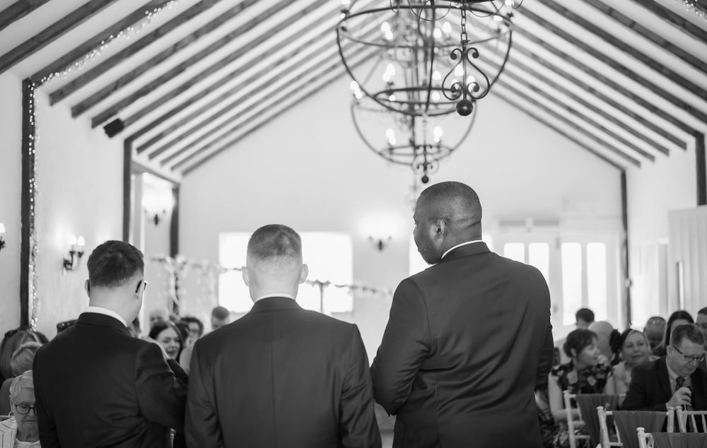 Wedding ceremony venue interior with guests seated and exposed beam cathedral ceiling.