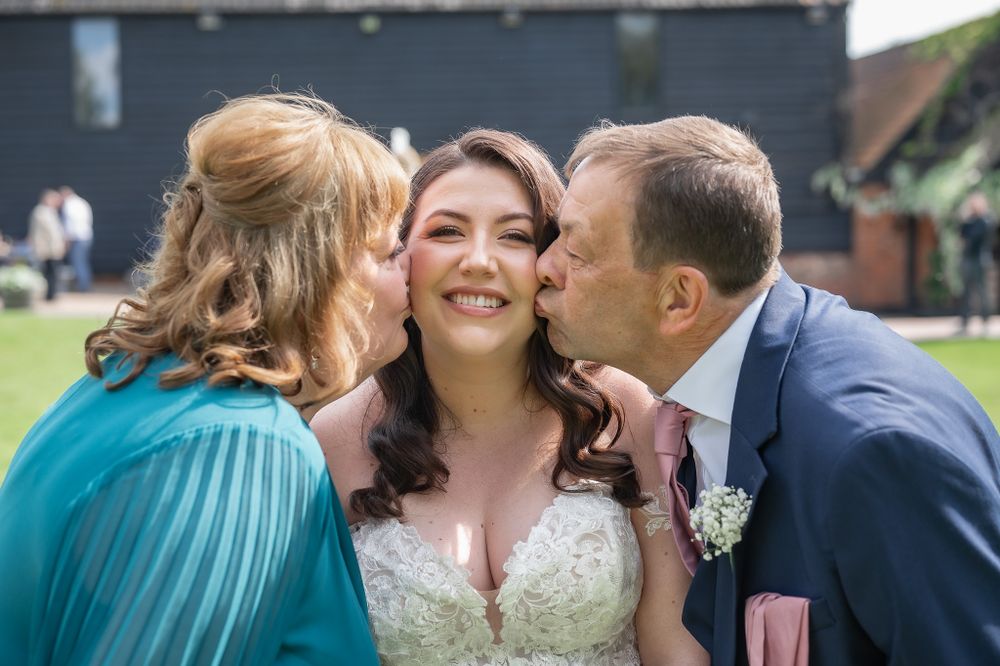Sweet candid wedding moment showing affection and joy at an outdoor venue.