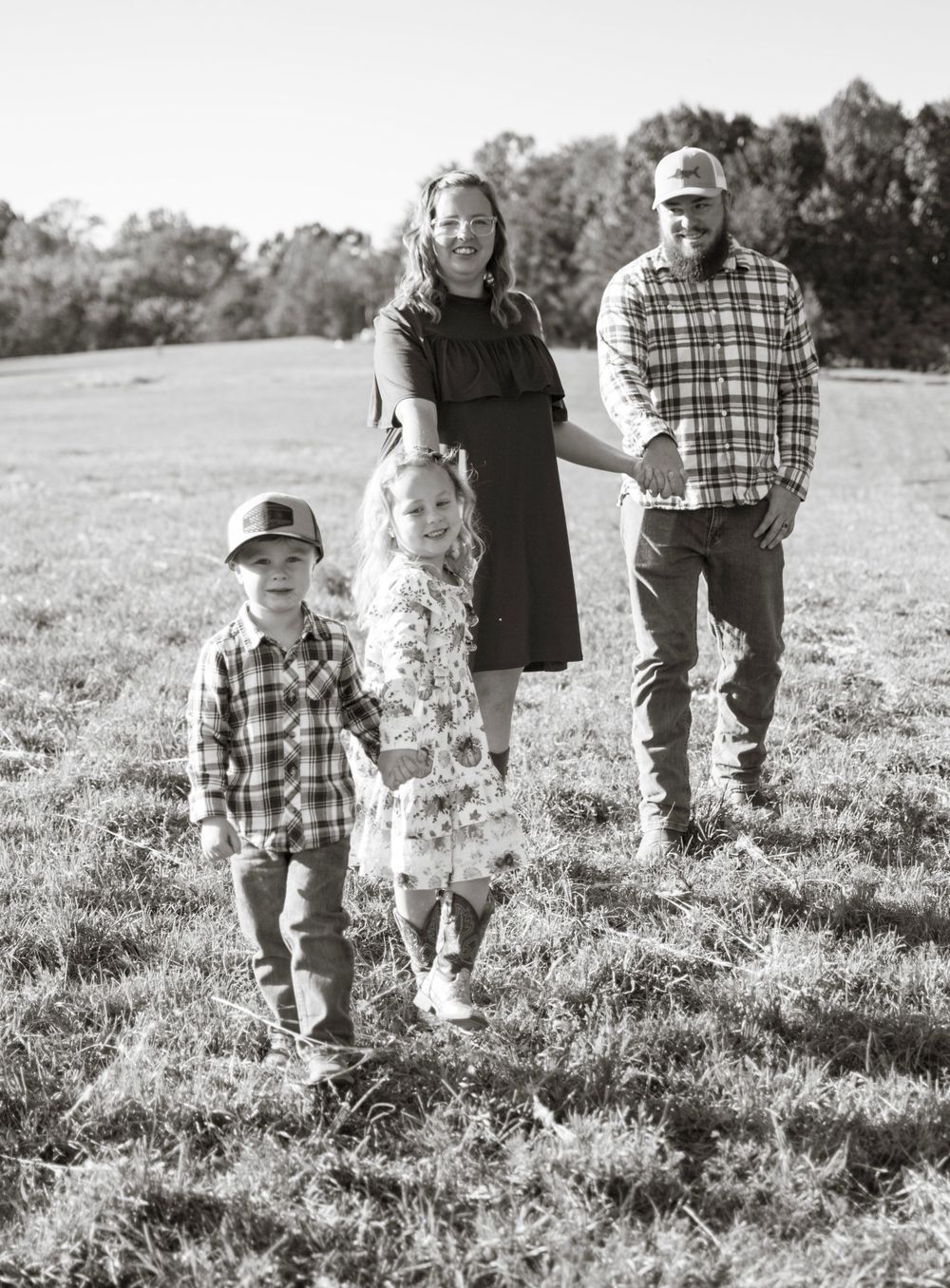 family walking across grass field for a family photo session