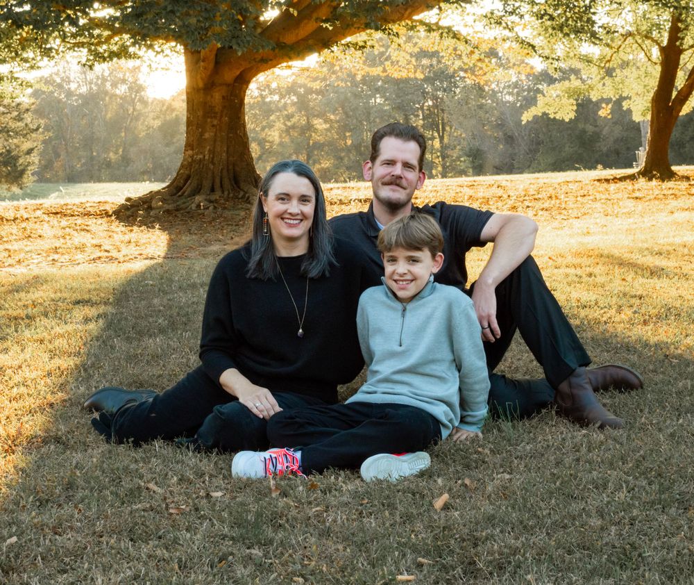 family sitting a field for a family photo session