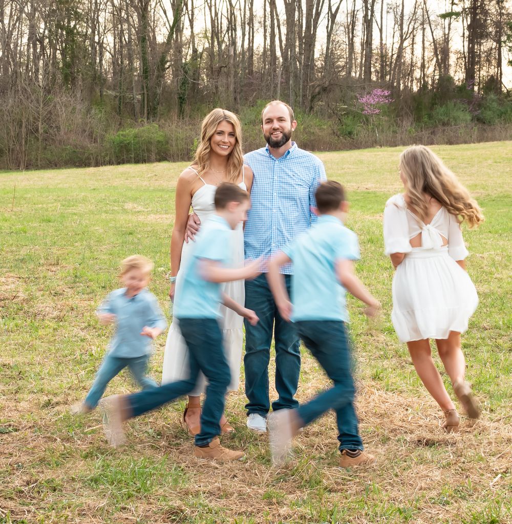 children running around parents that are posed for a family photo session
