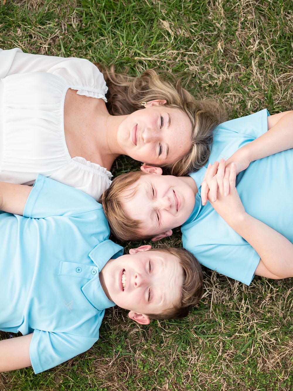 children posed side by side for a family photo session on the grass