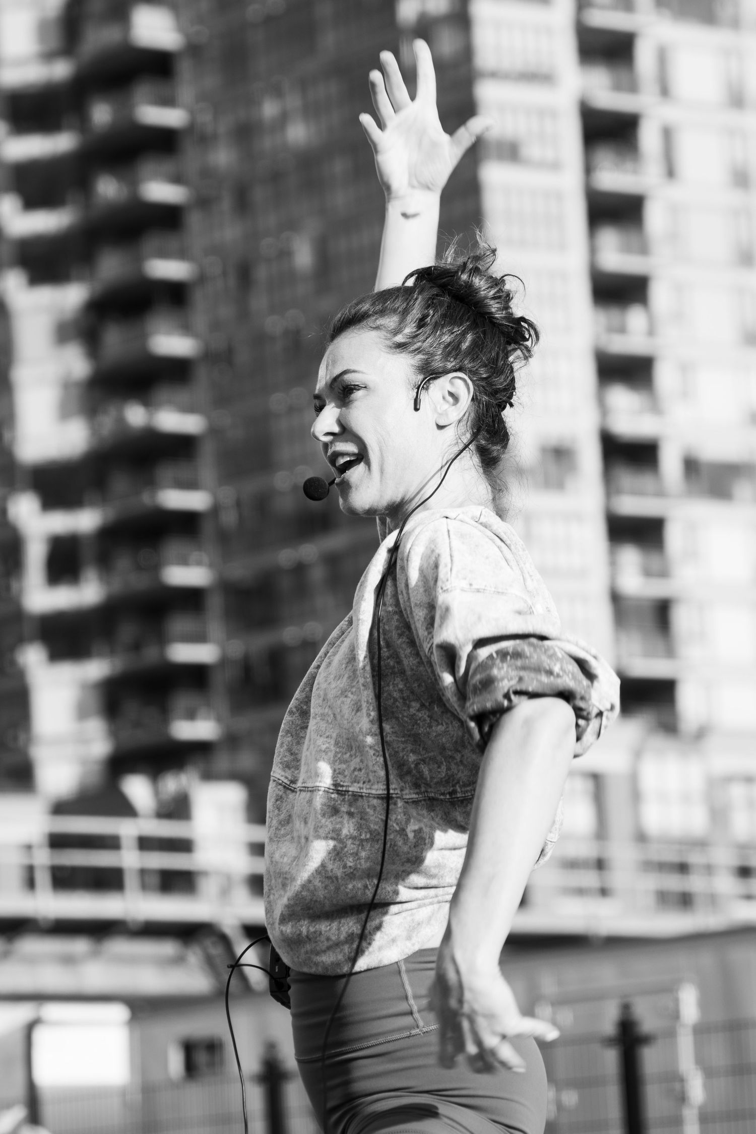 Black and white photo of energetic fitness instructor leading outdoor class.