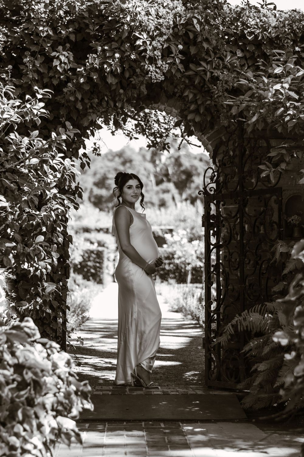 Artistic black and white photography in a garden walkway with ivy-covered walls.