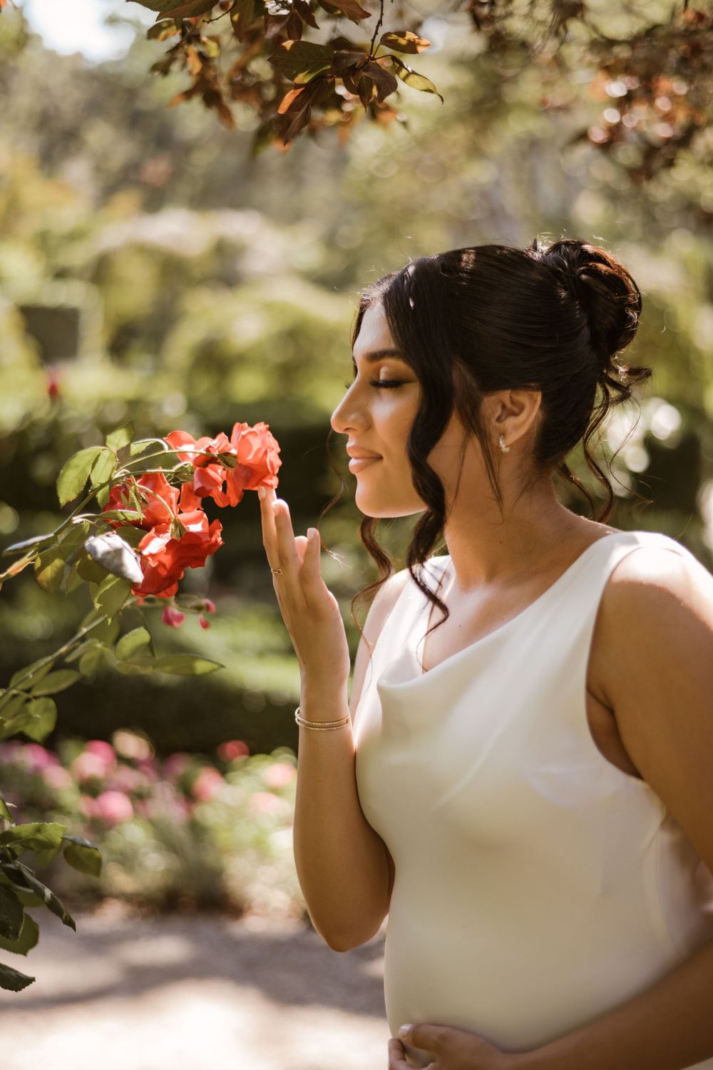 A delicate moment captured with coral flowers in a sunny garden setting.