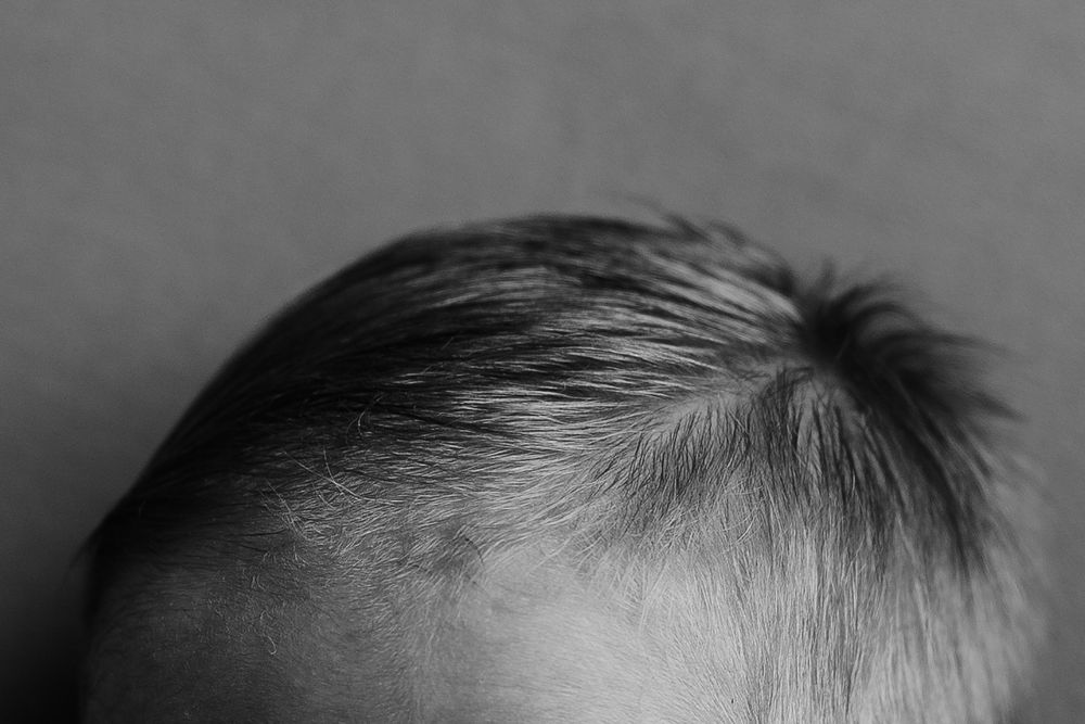 Black and white macro shot of baby's forehead and hair.