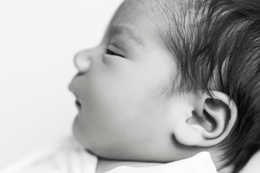Black and white close-up profile of baby's face showing ear and nose.