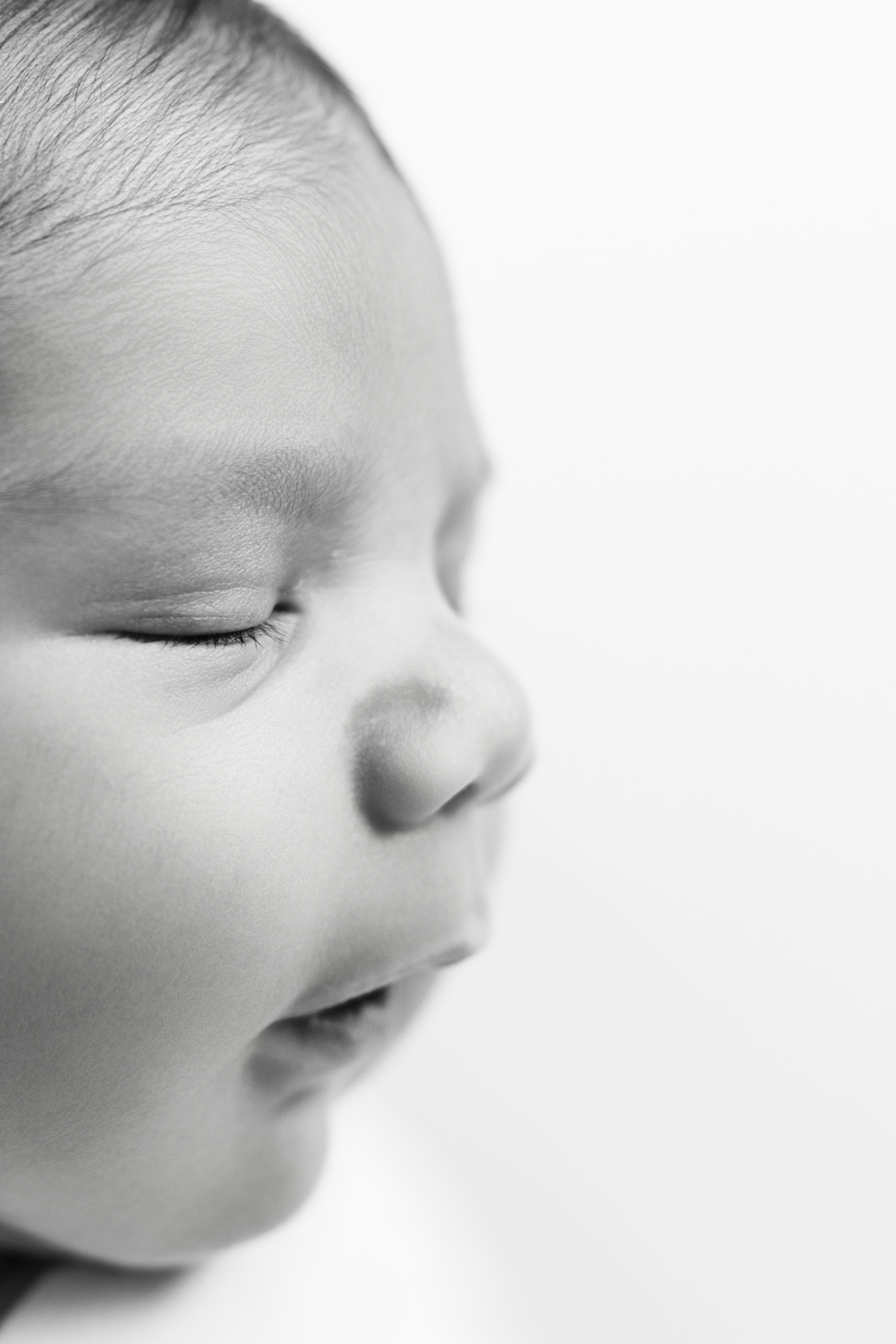 Close-up black and white portrait of peaceful sleeping baby's face.