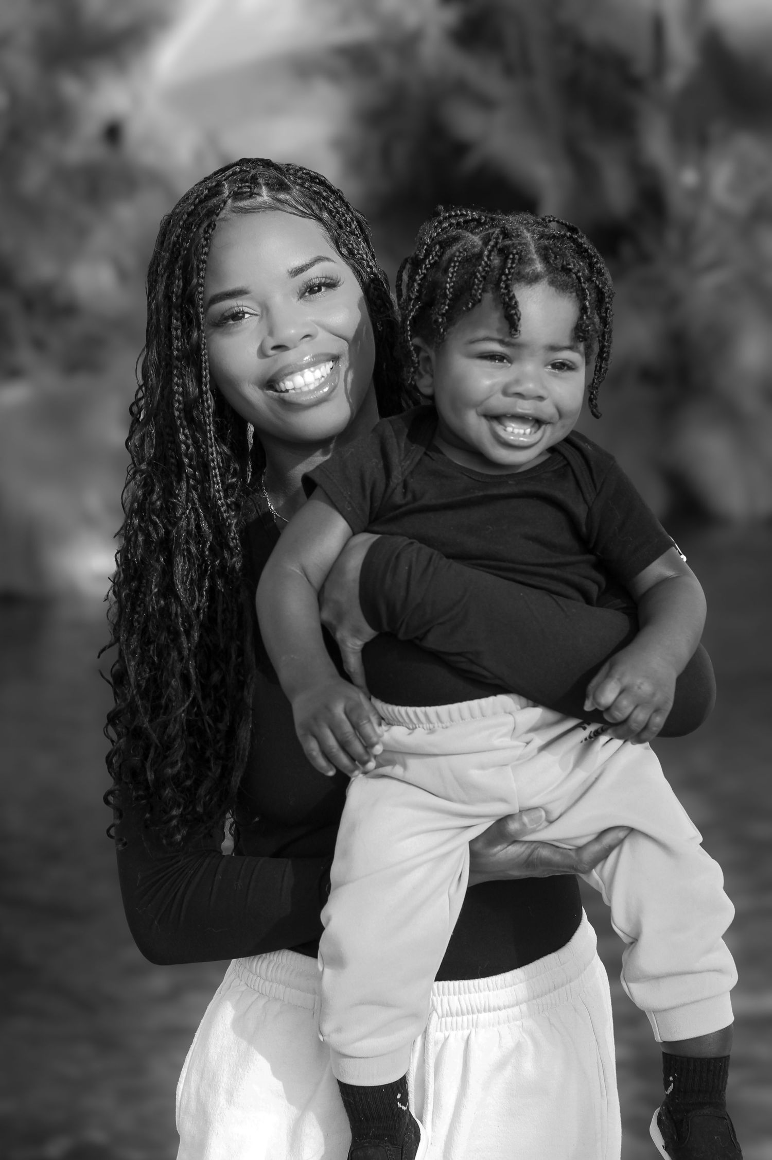 Black and white portrait showing joyful expressions and matching hairstyles.
