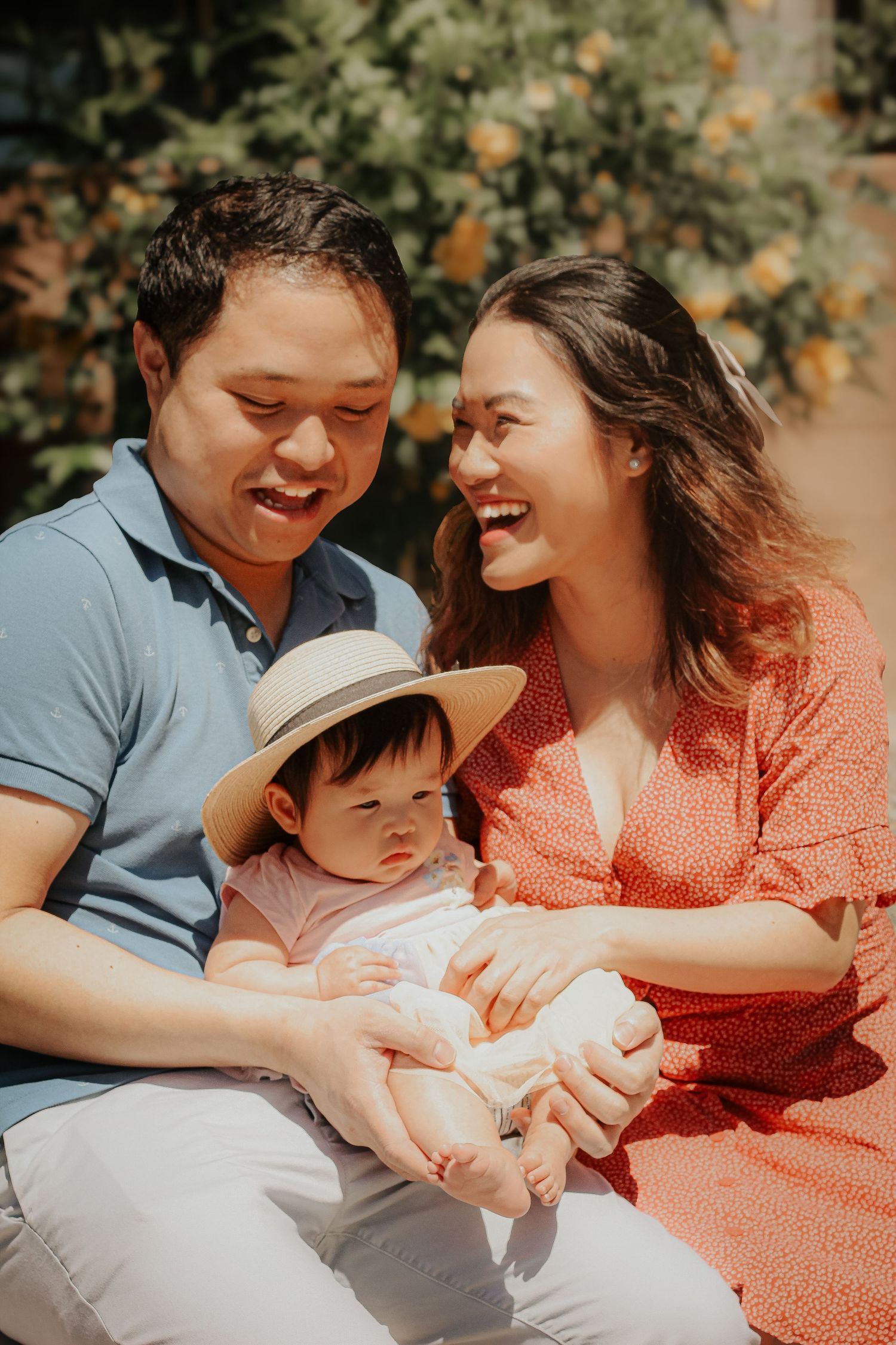 Young family sharing joyful moment together in sunlit garden setting.
