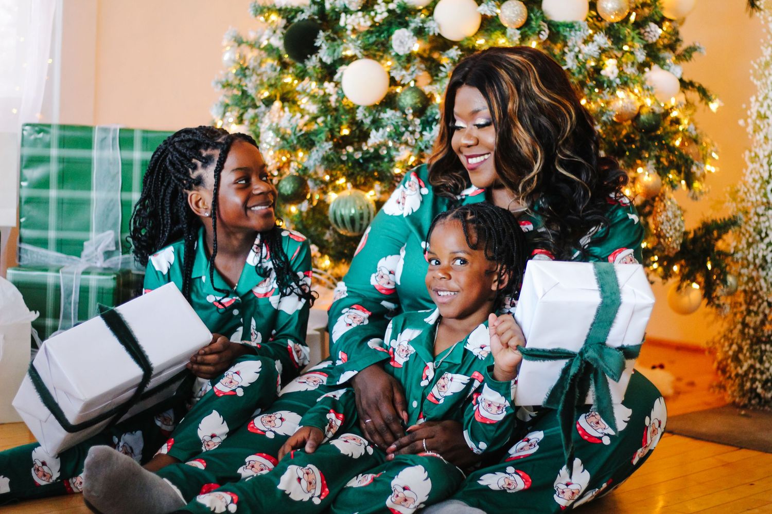 A group wearing matching green and white outfits sits together laughing and smiling during a festive gathering.