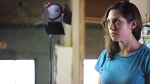 Film set with professional lighting equipment in an industrial space.