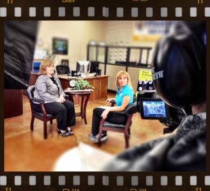 Behind-the-scenes view of a video interview being filmed in an office setting.