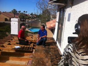 Behind-the-scenes filming of an outdoor interview on a patio with a pool visible.