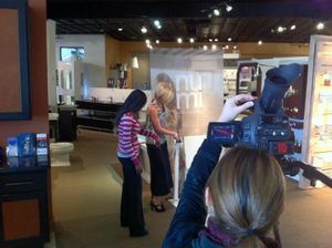 Video production crew filming an interview inside a retail store.