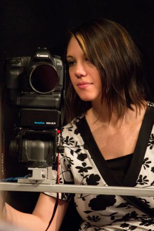 Photographer with a Canon DSLR camera and flash setup in studio setting.
