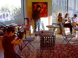 Photography session in cafe setting with red wall art and casual atmosphere.