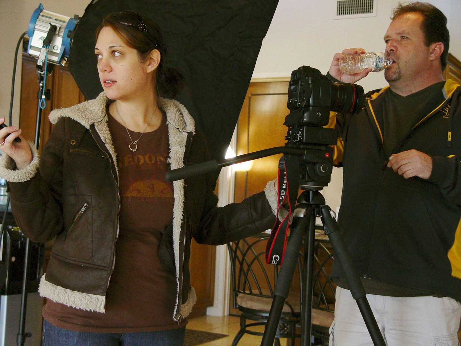Two photographers working with professional camera equipment in studio.