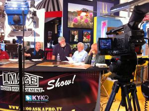 Television studio setup with cameras filming talk show hosts at desk.
