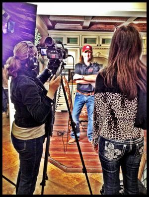 Film crew setting up shot with camera equipment in indoor location.