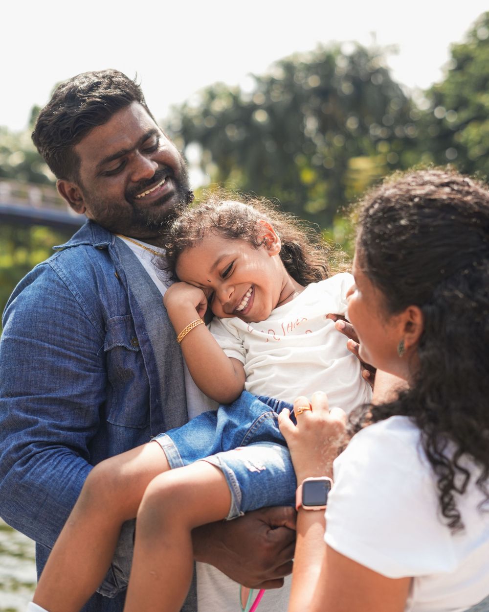 A family shares a warm moment of laughter together in an outdoor setting.