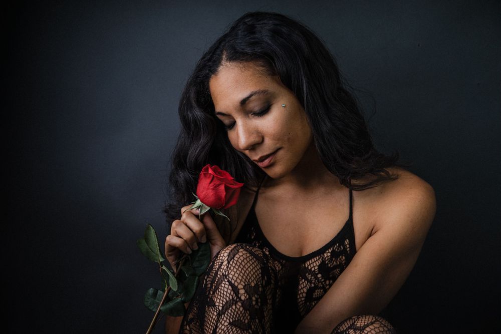 Boudoir portrait of female holding a rose in a photography studio by a  photographer located in Dandridge TN in East Tennessee