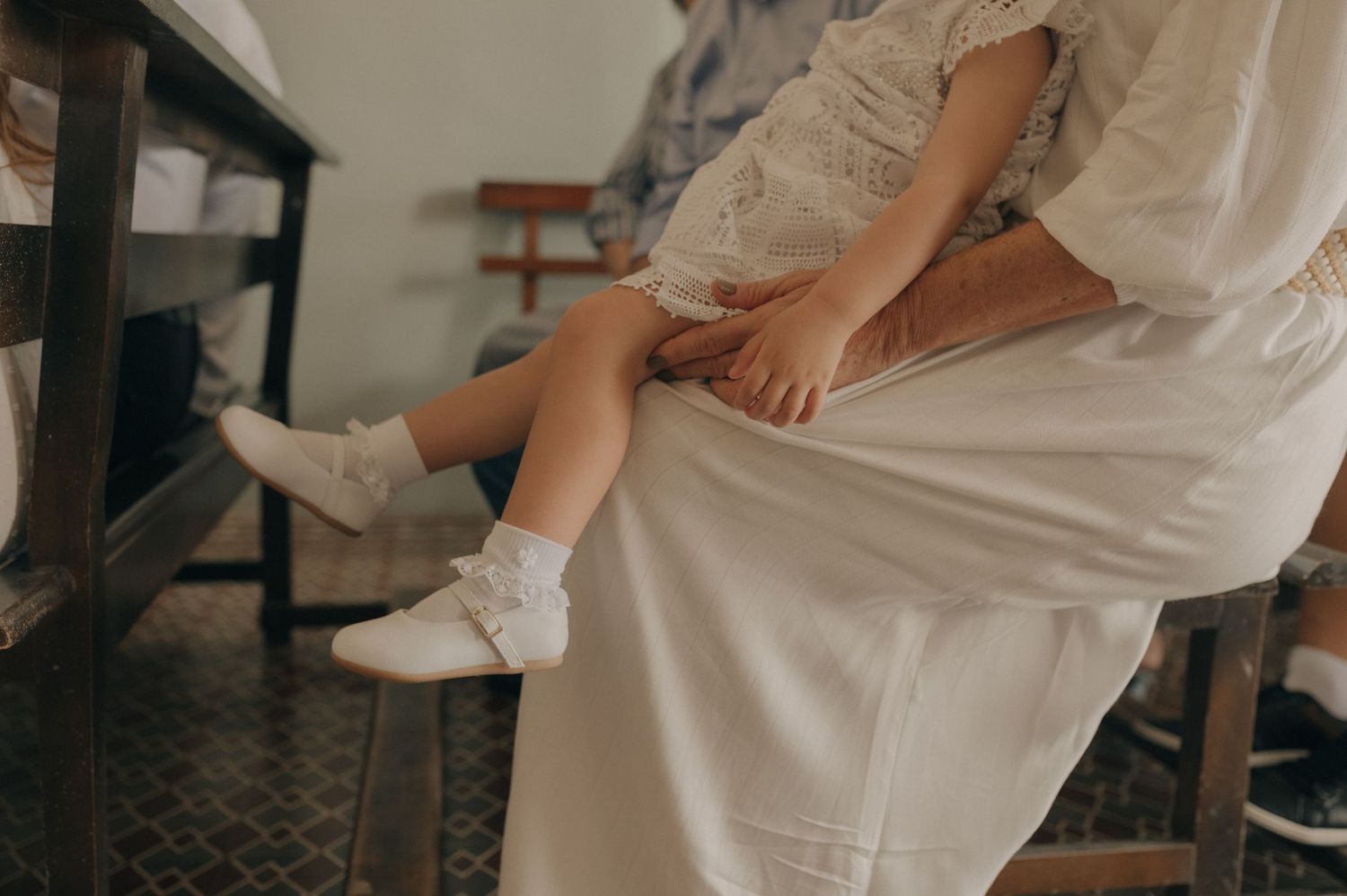 White ruffled socks and shoes shown on feet against a dark floor.