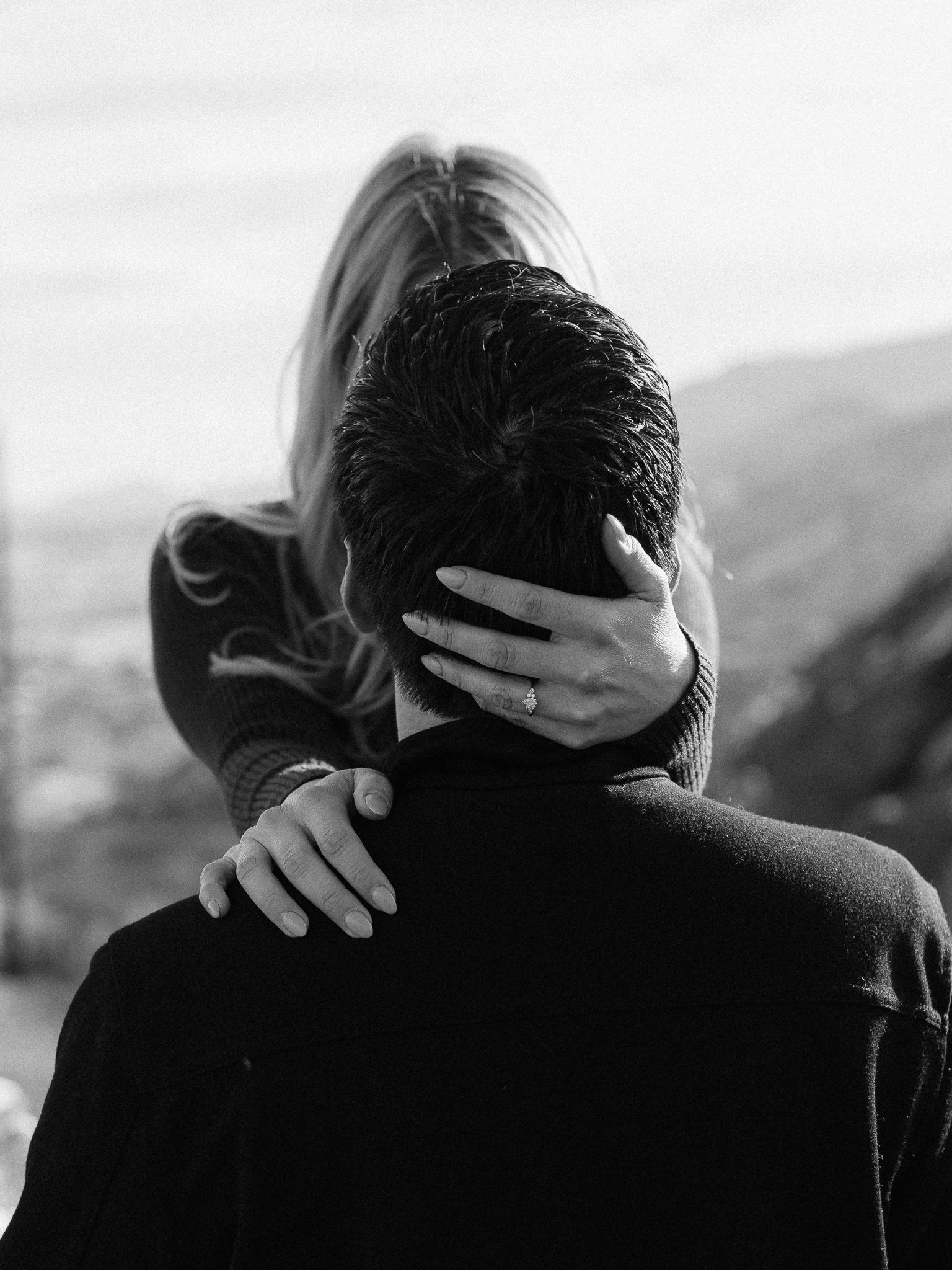 Black and white photos show a couple embracing in silhouette against a mountain backdrop.