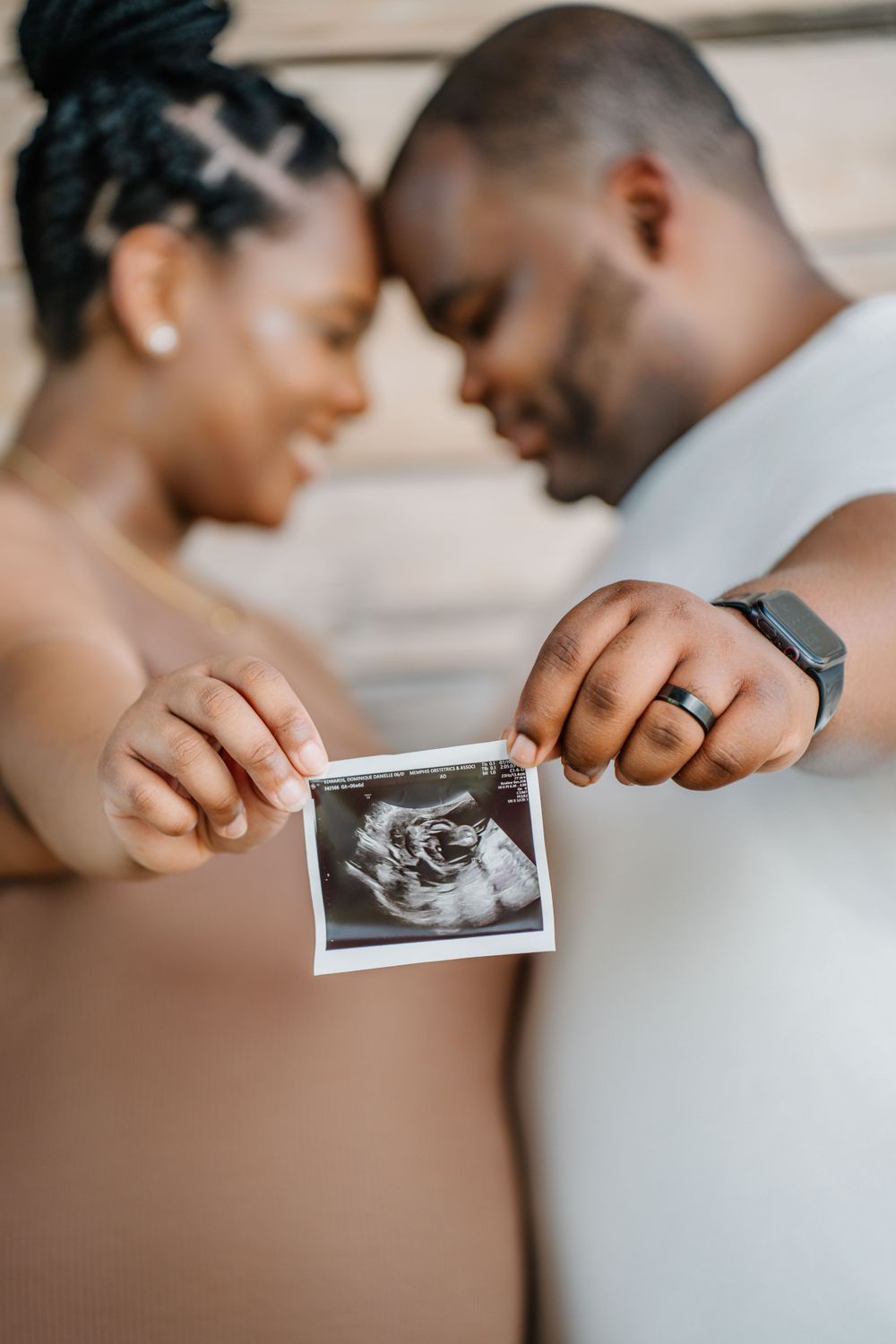 A couple examines an ultrasound photo together in an intimate moment.