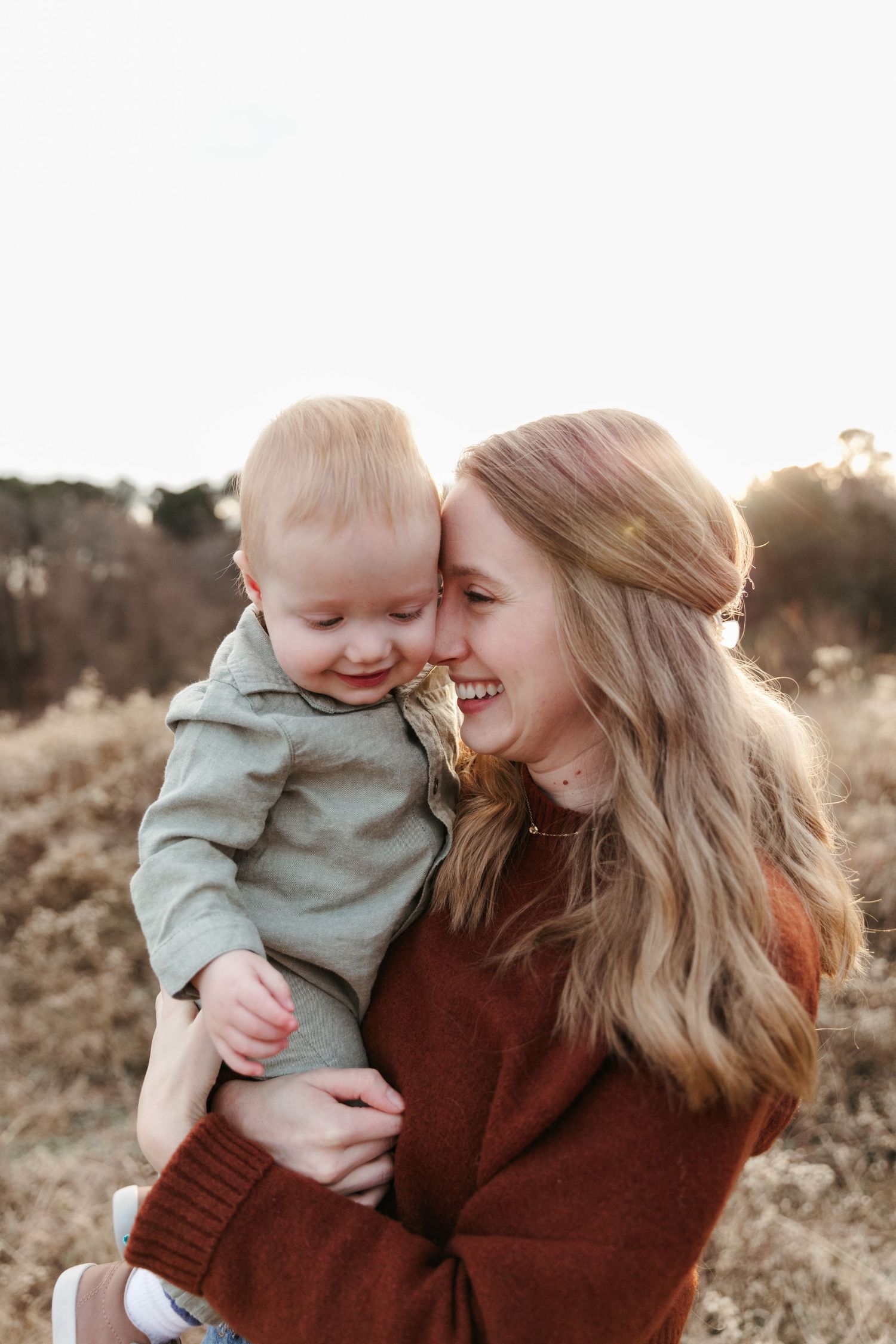 A warm and joyful outdoor photoshoot during golden hour in a natural field setting.