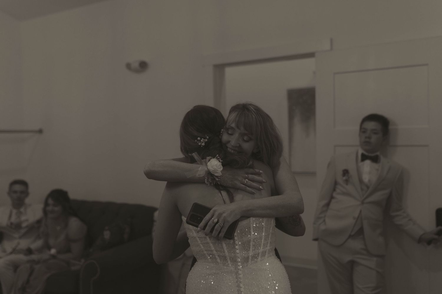 Wedding celebration in a bright modern venue with people dancing and embracing.