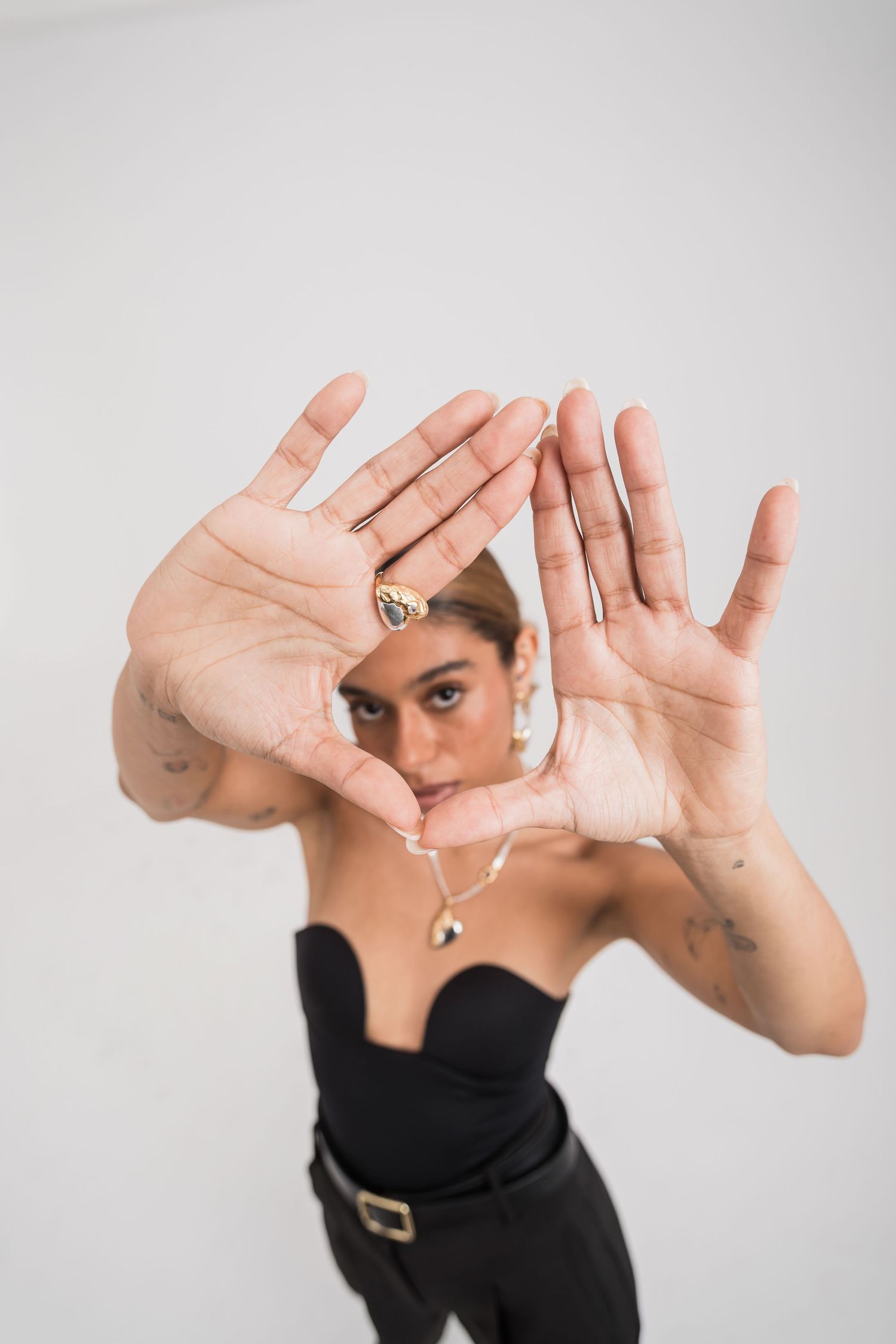 Artistic photo of hands framing face against white background.