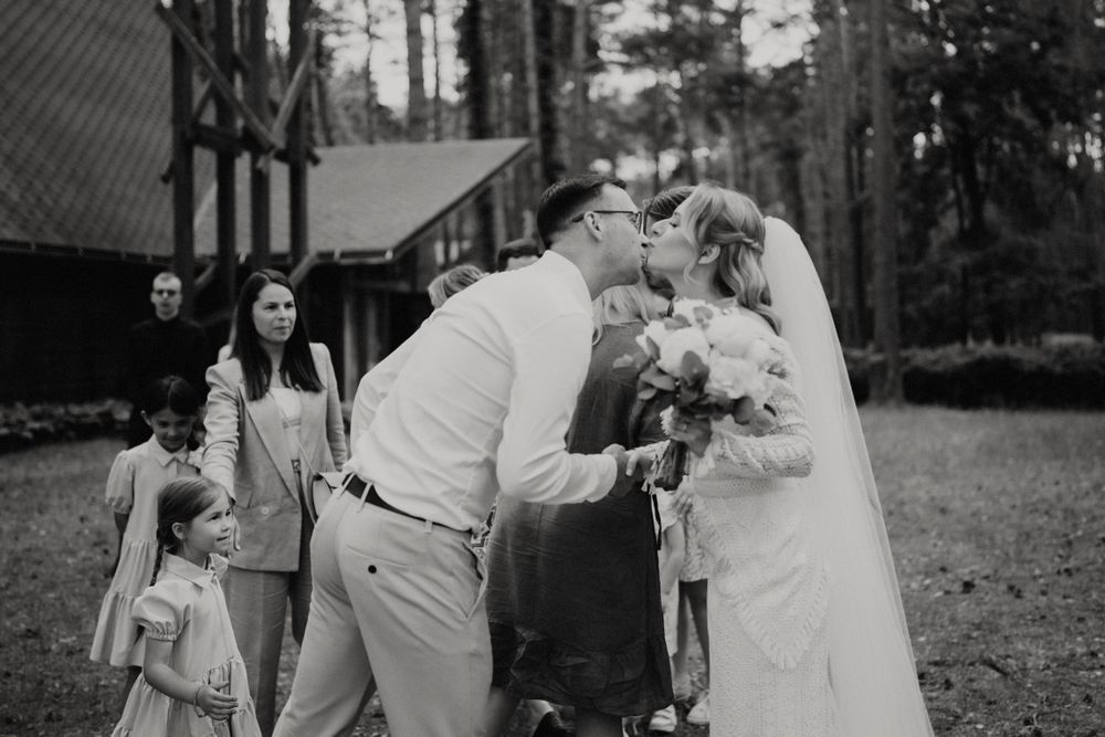 Black and white wedding party candid photos in a forest setting.