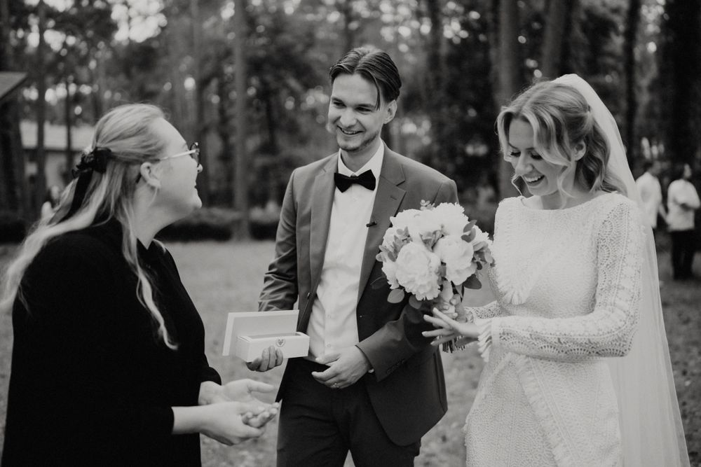 Wedding guests mingle and celebrate at an outdoor forest reception.