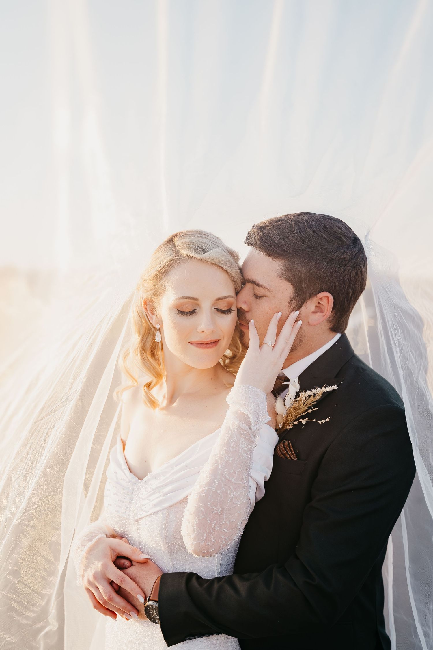 bride and groom sharing a moment underneath her flowy veil on their safari wedding at Bona Bona Game Lodge in South Africa