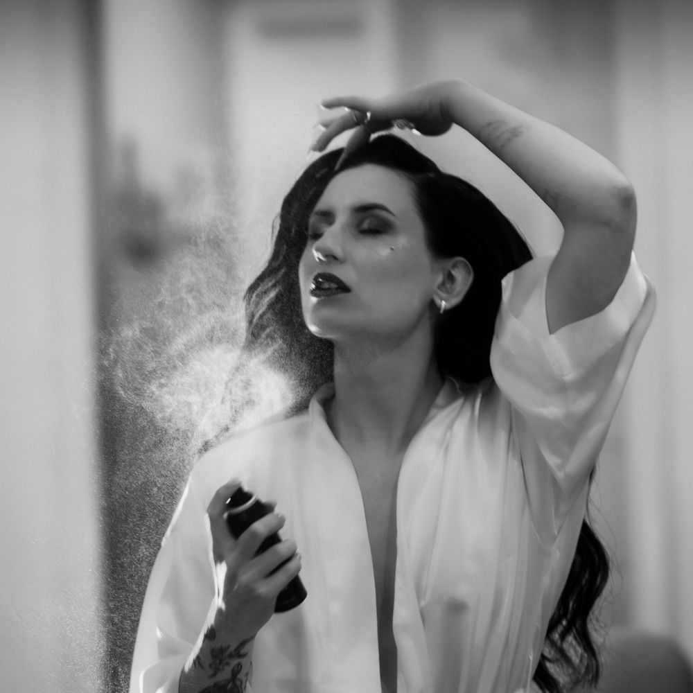 Dramatic black and white portrait with hair spray creating misty effect.