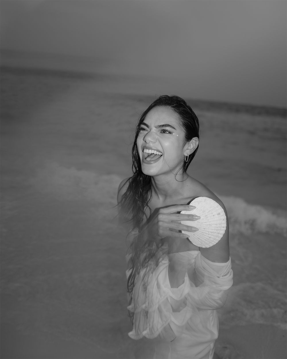 Black and white beach portrait showing joy and laughter.