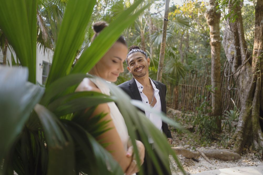 Romantic moment between couple in tropical garden setting with lush foliage.