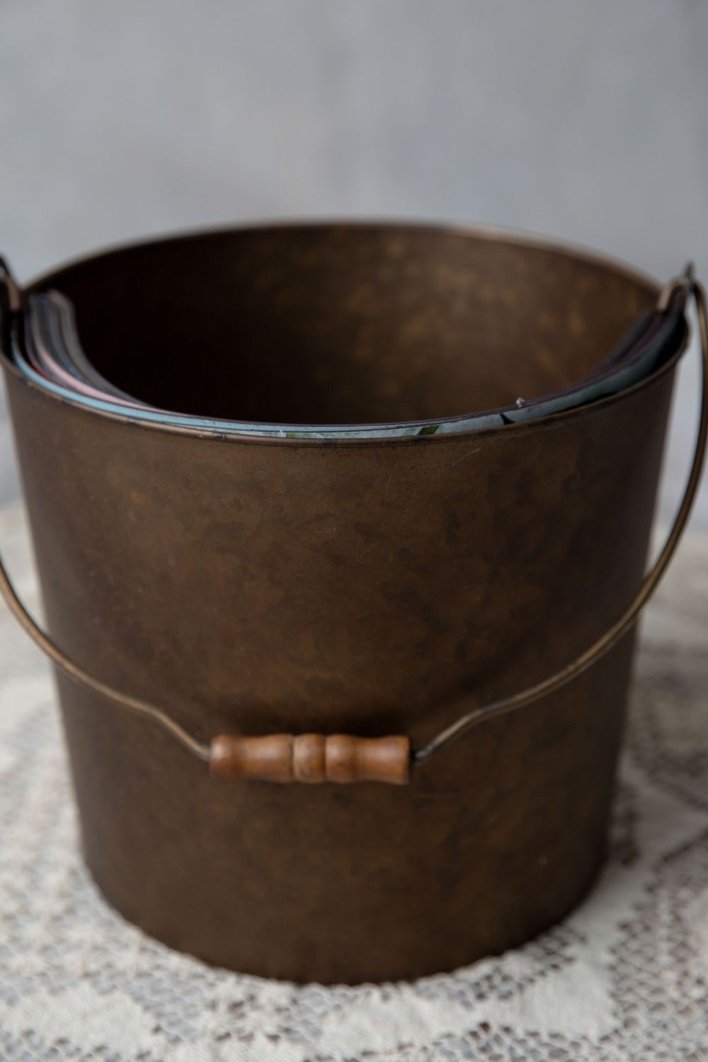 Antique-style dark bronze metal bucket with wooden-handled wire bail and aged patina finish.