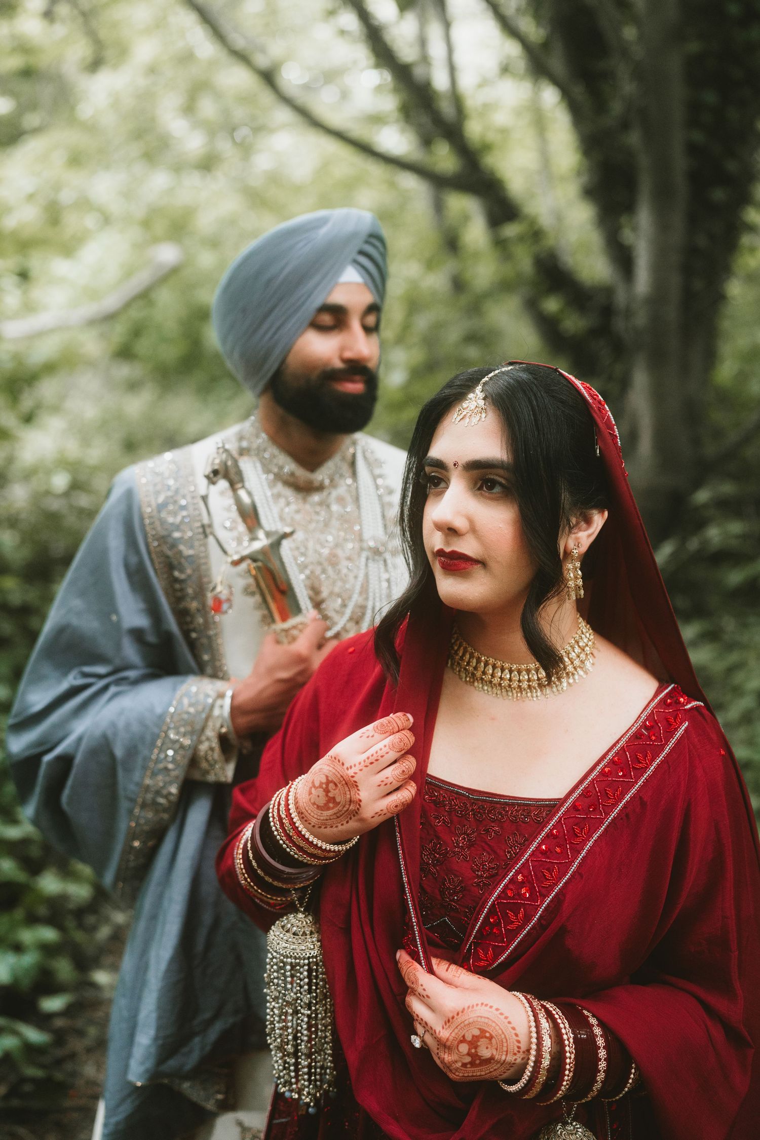 A couple walking hand in hand through an elegant hotel hallway wearing formal evening attire.