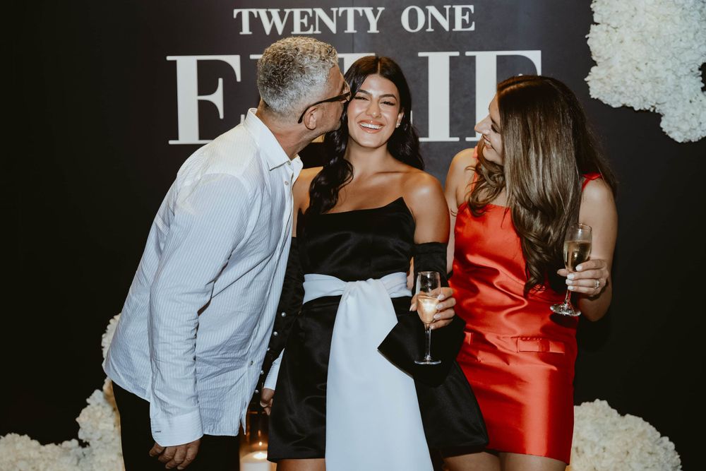 Three guests enjoying drinks and conversation at formal twenty-one event.