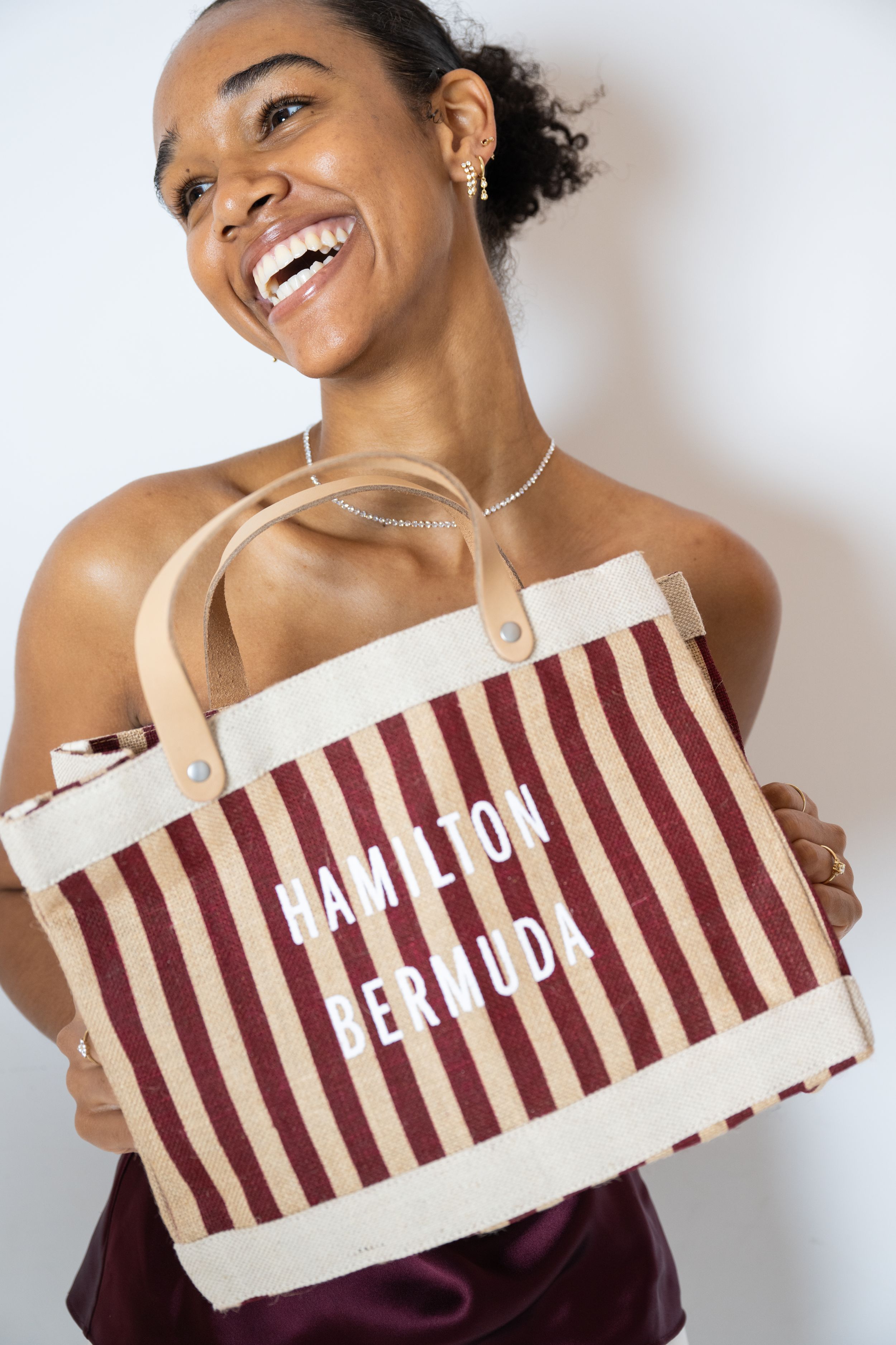 Striped canvas tote bag with text reading 'Camp for Her 100' displayed against white background.