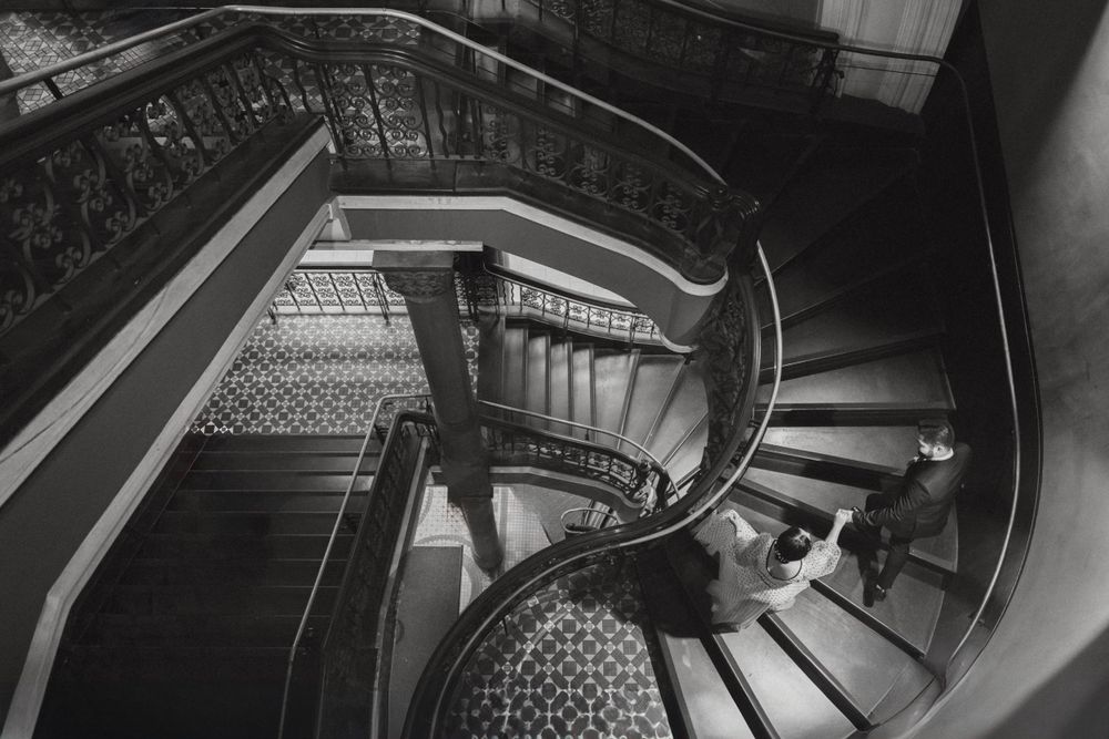 Dramatic black and white spiral staircase shot from above showing architectural details.