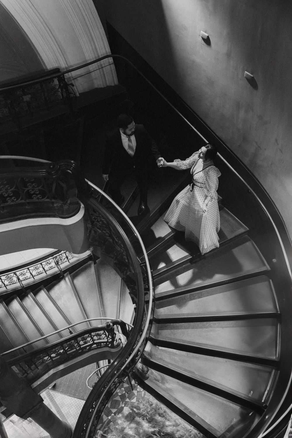 Artistic black and white photo of a curved staircase with dramatic shadows and lighting.
