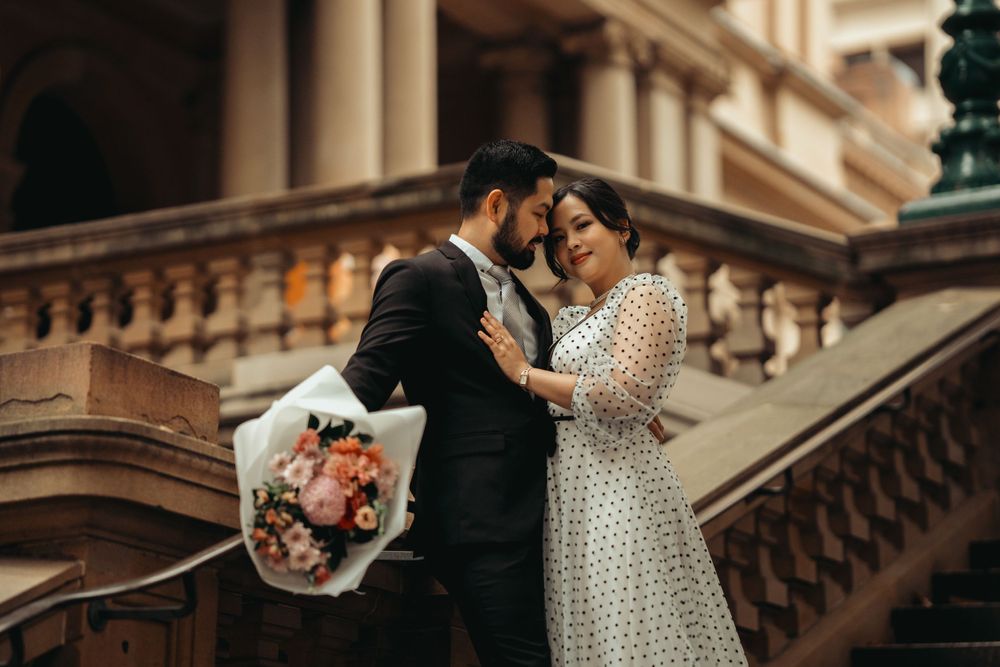 Intimate wedding portrait on classical stone steps with warm lighting and romantic atmosphere.